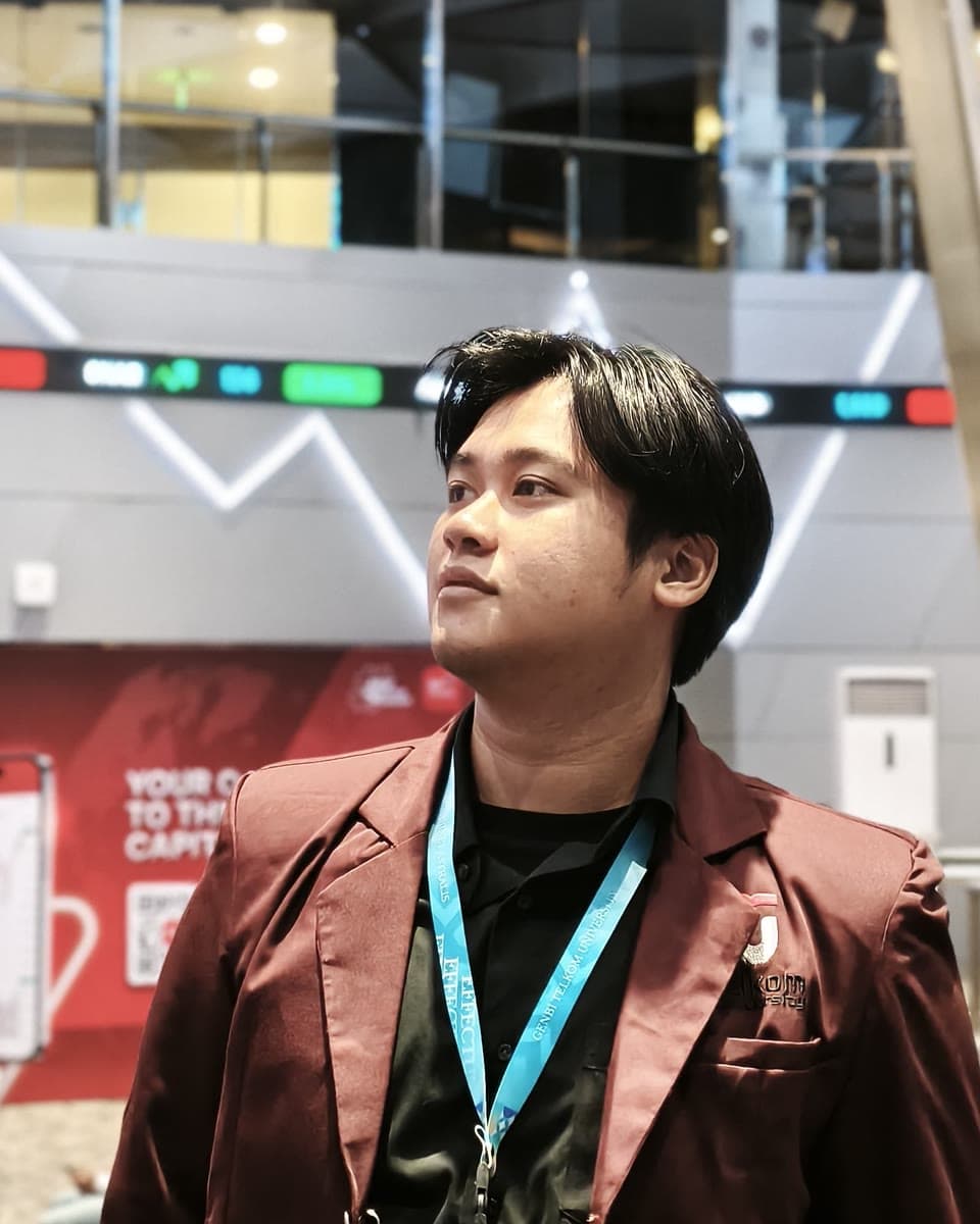 Wildan Syukri Niam at a technology event, wearing a maroon blazer.